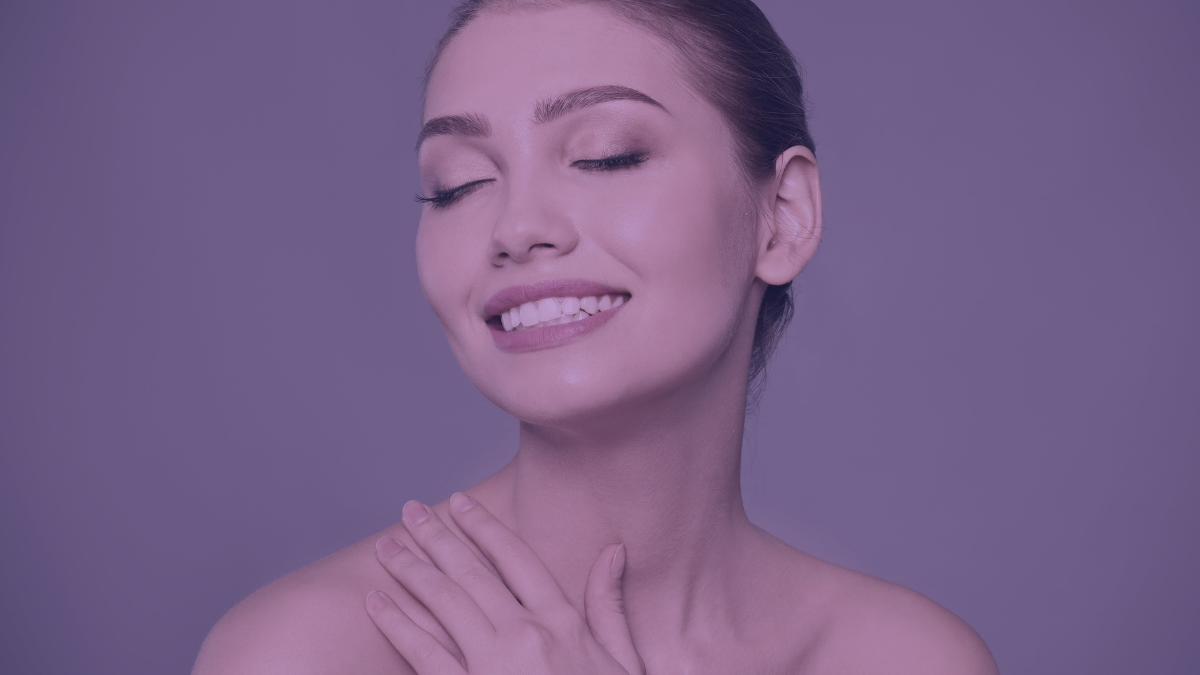 A woman with clean and clear acne-free face smiling with her eyes closed.